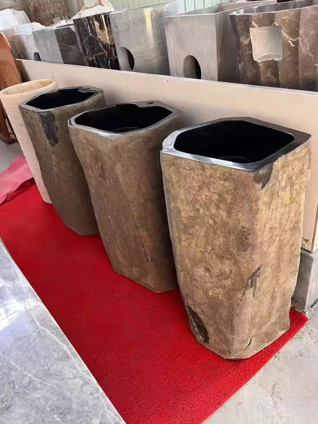 Four Wabi Sabi - Standing Marble Basin Sinks by Lise Luxury on a red carpet.