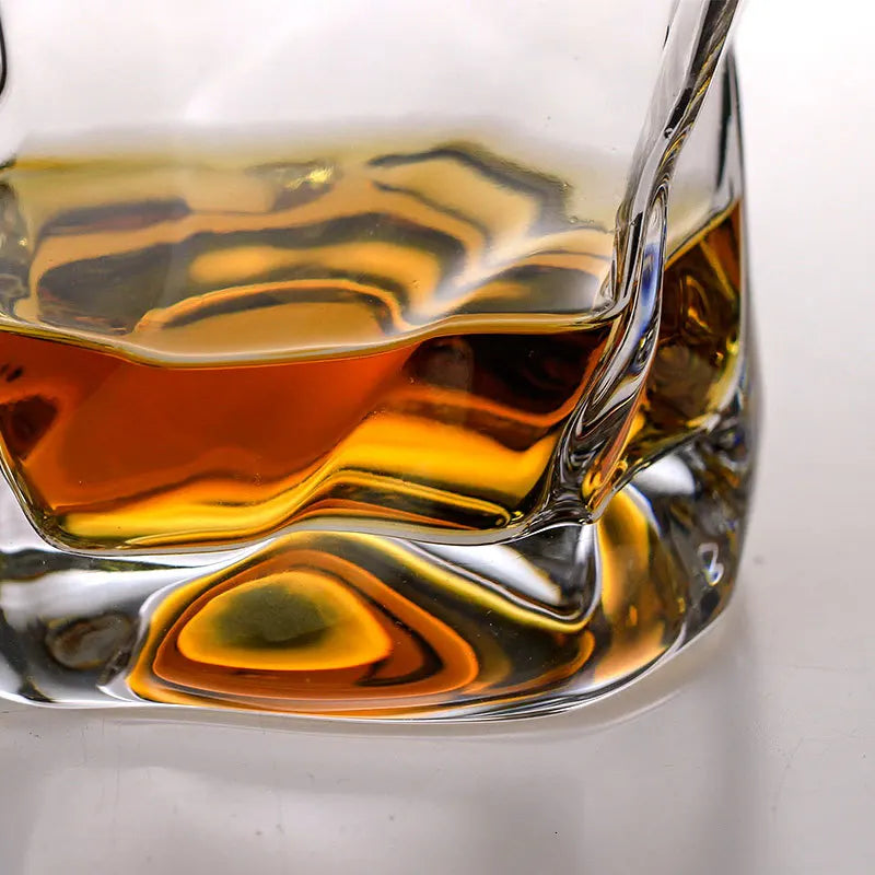 A glass of Lise Luxury Japanese Design Whiskey glass with a rich aroma on a wooden coaster with its packaging box in the background.