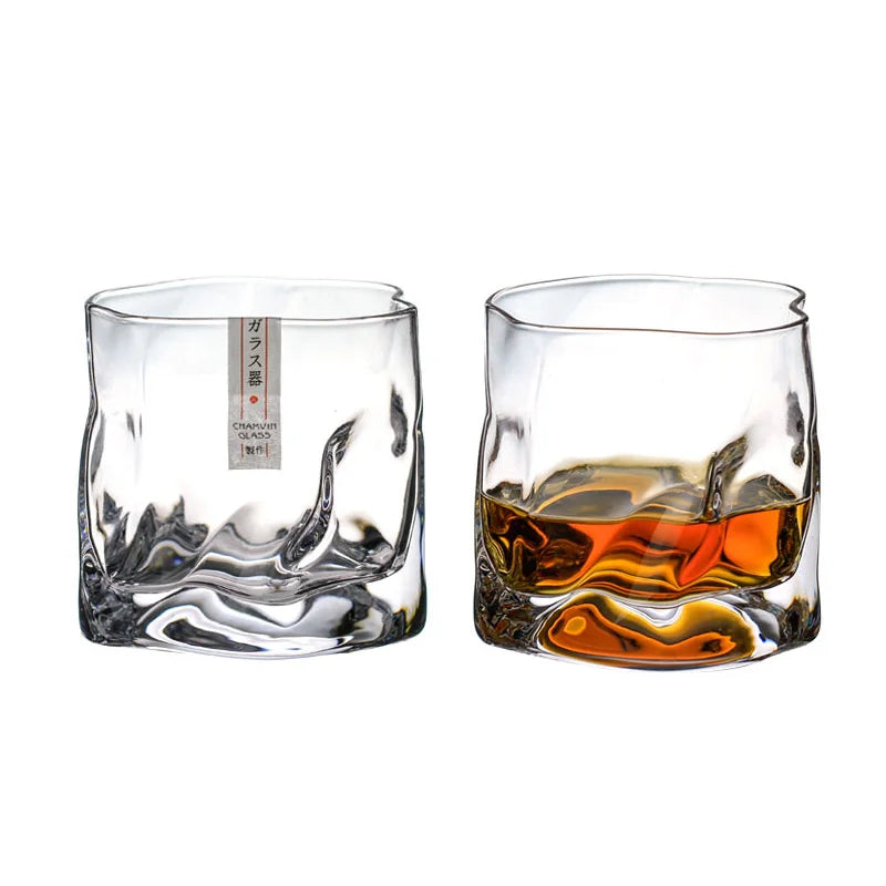 A glass of Lise Luxury Japanese Design Whiskey glass with a rich aroma on a wooden coaster with its packaging box in the background.