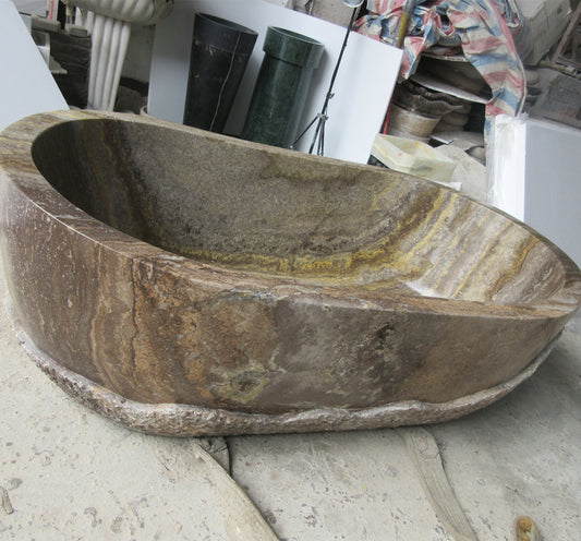 Lise Luxury's Down to Earth Marble Bath Tub with a natural, unfinished exterior sits elegantly on a concrete floor.