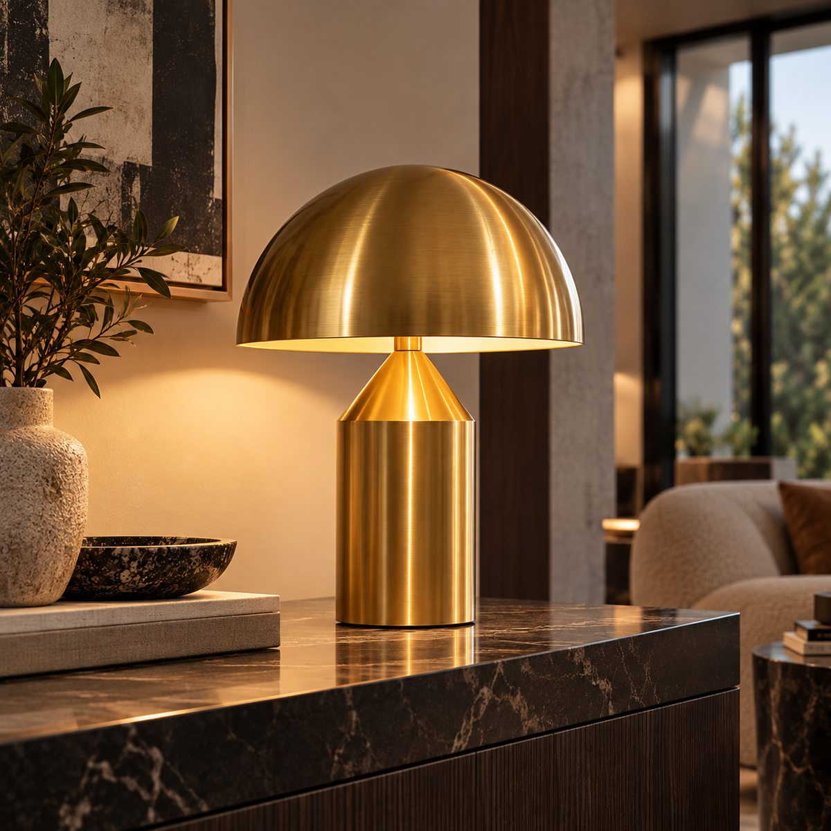 [color: gold] A modern mushroom-shaped table lamp in polished brass sits on a dark marble console table in a stylishly decorated living room.