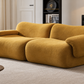 A modern modular sofa upholstered in a textured mustard yellow fabric, styled in a contemporary living room setting.
