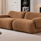 A modern, rounded modular sofa upholstered in a textured brown fabric, styled in a contemporary living room setting.
