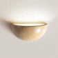 Sparkling Stella half-dome wall light by Lise Luxury illuminating a bedroom wall with a warm glow.