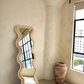 Rose wavy full-length floor mirror with an organic sculptural frame in a sunlit modern interior
