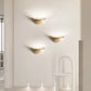 Sparkling Stella half-dome wall light by Lise Luxury illuminating a bedroom wall with a warm glow.