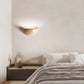 Sparkling Stella half-dome wall light by Lise Luxury illuminating a bedroom wall with a warm glow.