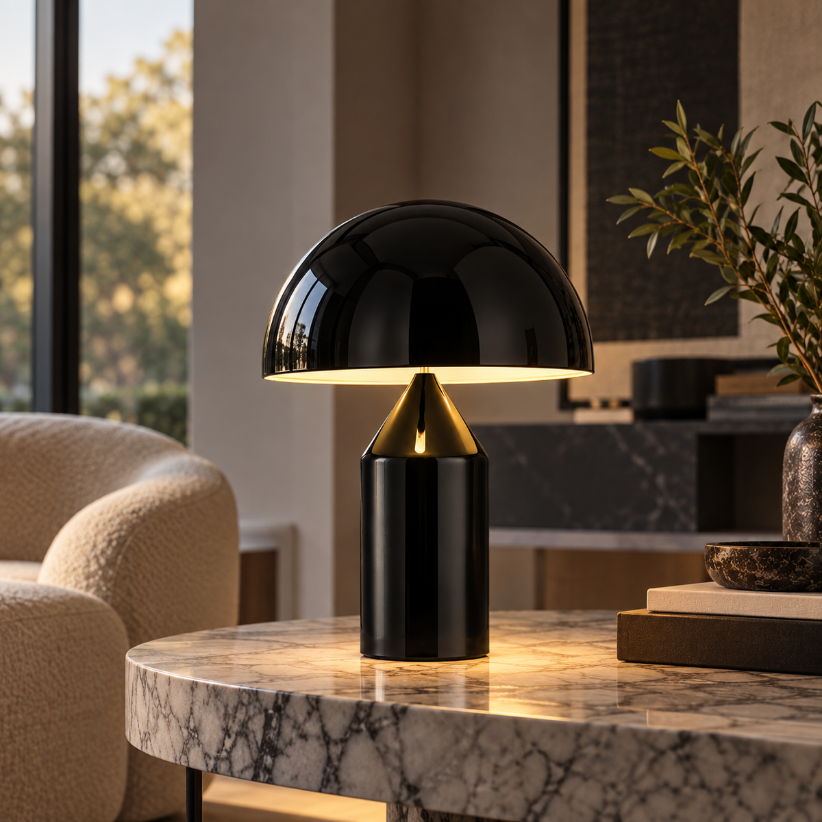 [color: black] A modern table lamp with a glossy black dome-shaped shade and a black cylindrical base accented by a gold metallic collar, illuminated on a marble-topped table in a contemporary living room setting.