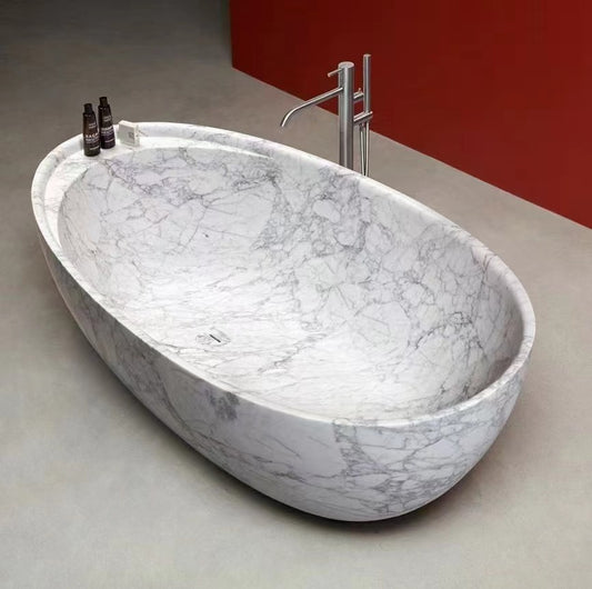 Elegant luxury Lise Luxury marble bathtub with sleek fixtures on a grey floor.