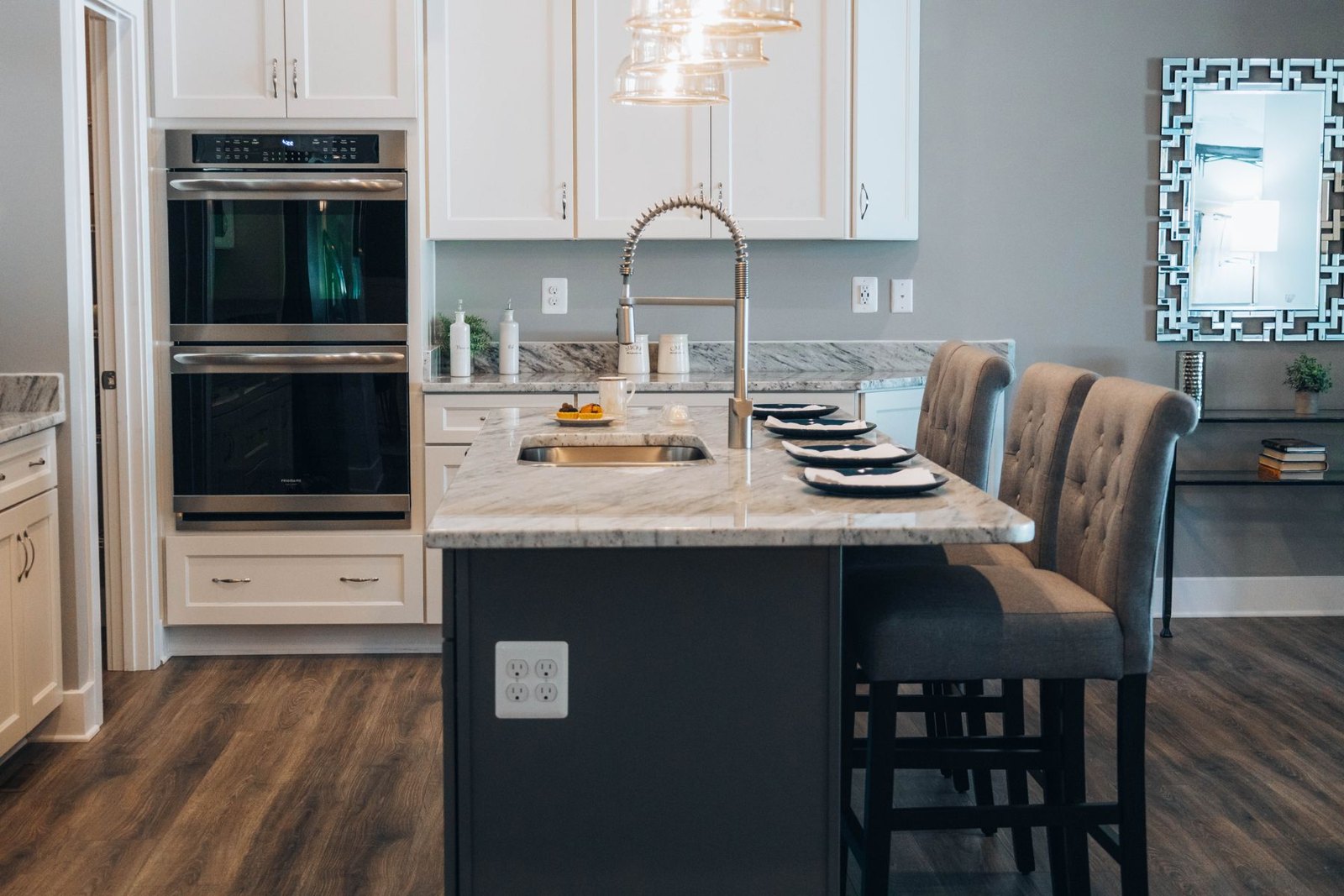 Kitchen island with stools, pendant lighting and adjacent cabinetry