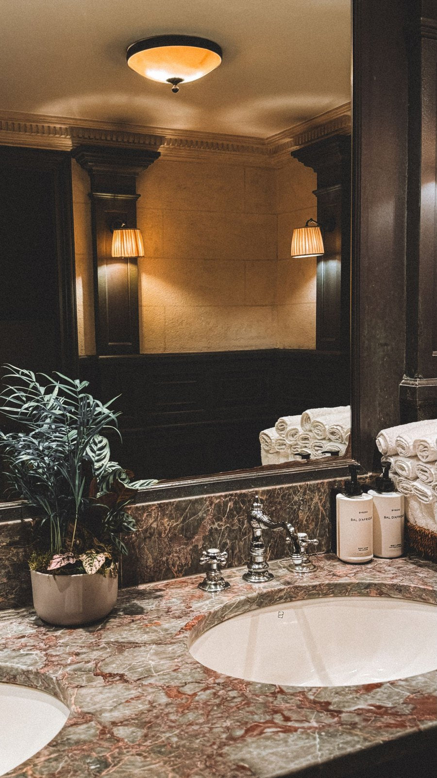 Bathroom basin set into a patterned counter with mirror and toiletries