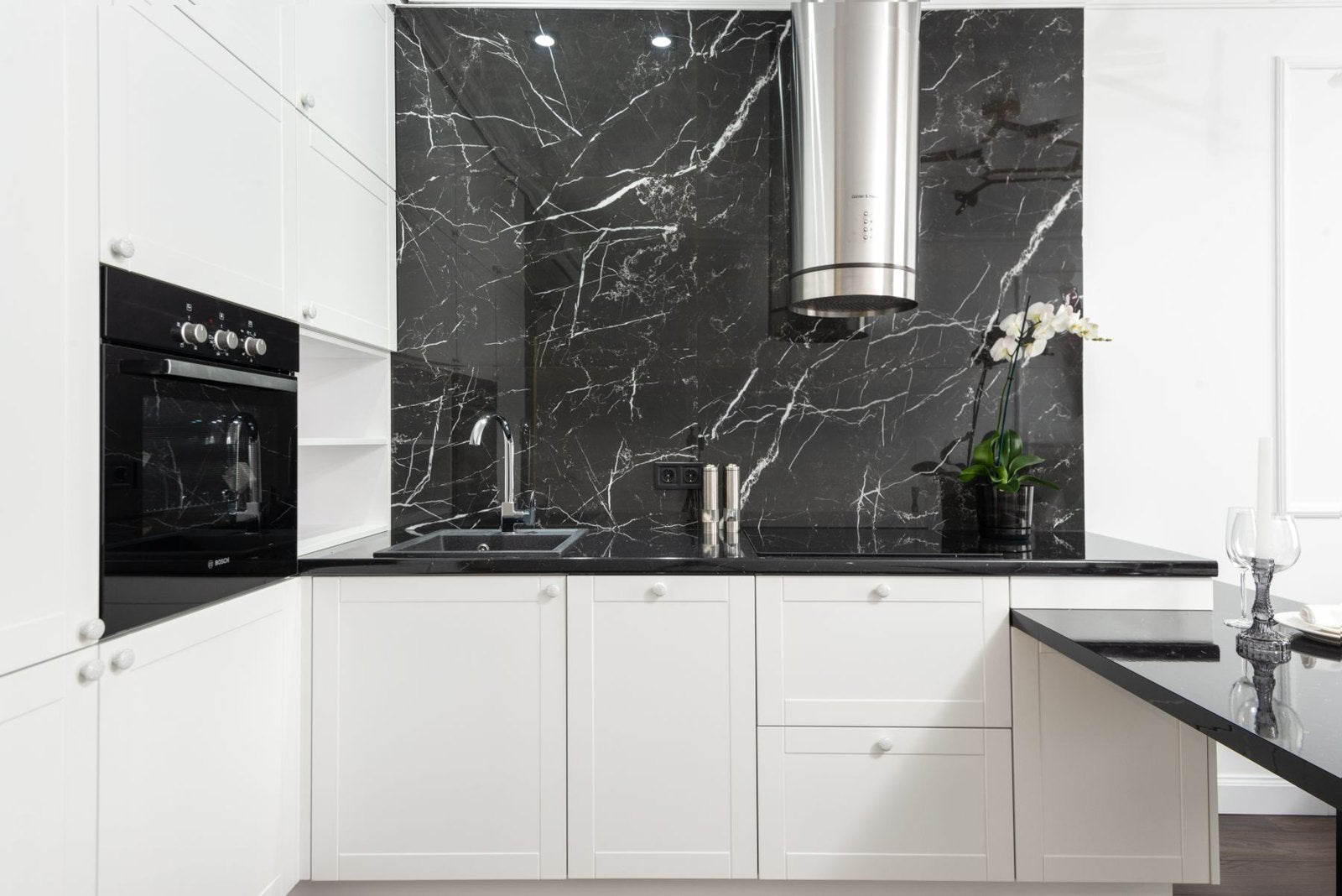 White kitchen cabinets against a dark veined backsplash