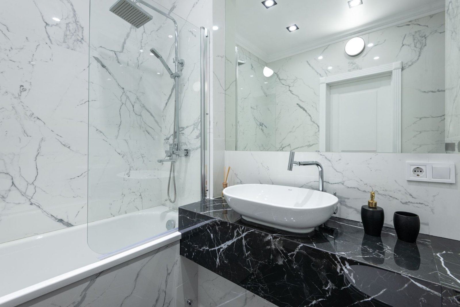 White vessel basin on a dark veined vanity in a light bathroom