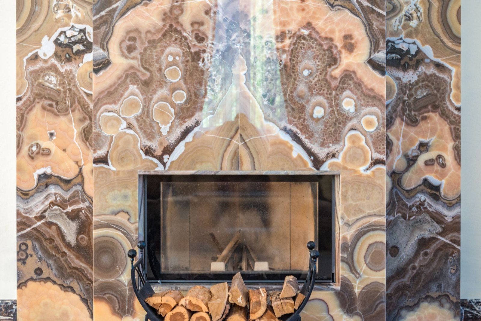 Fireplace framed by mirrored warm-coloured veined wall panels