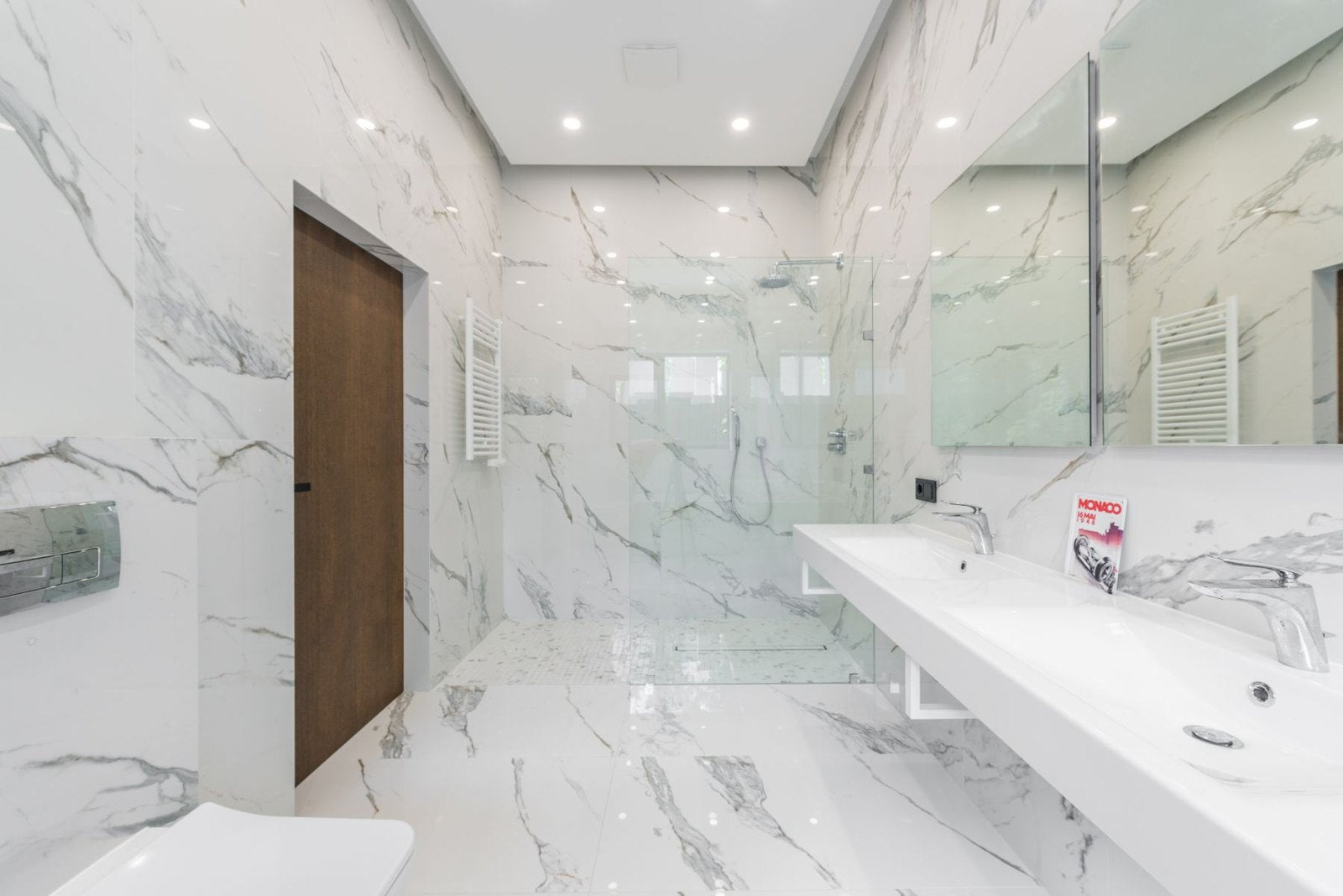 Light veined bathroom walls with double vanity and glass shower