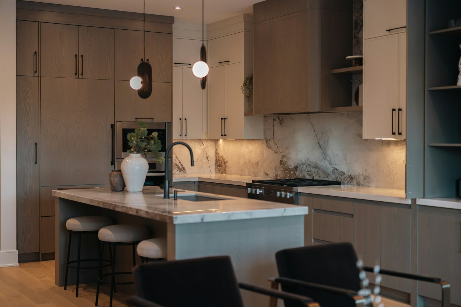 Kitchen island and veined backsplash with warm timber cabinets