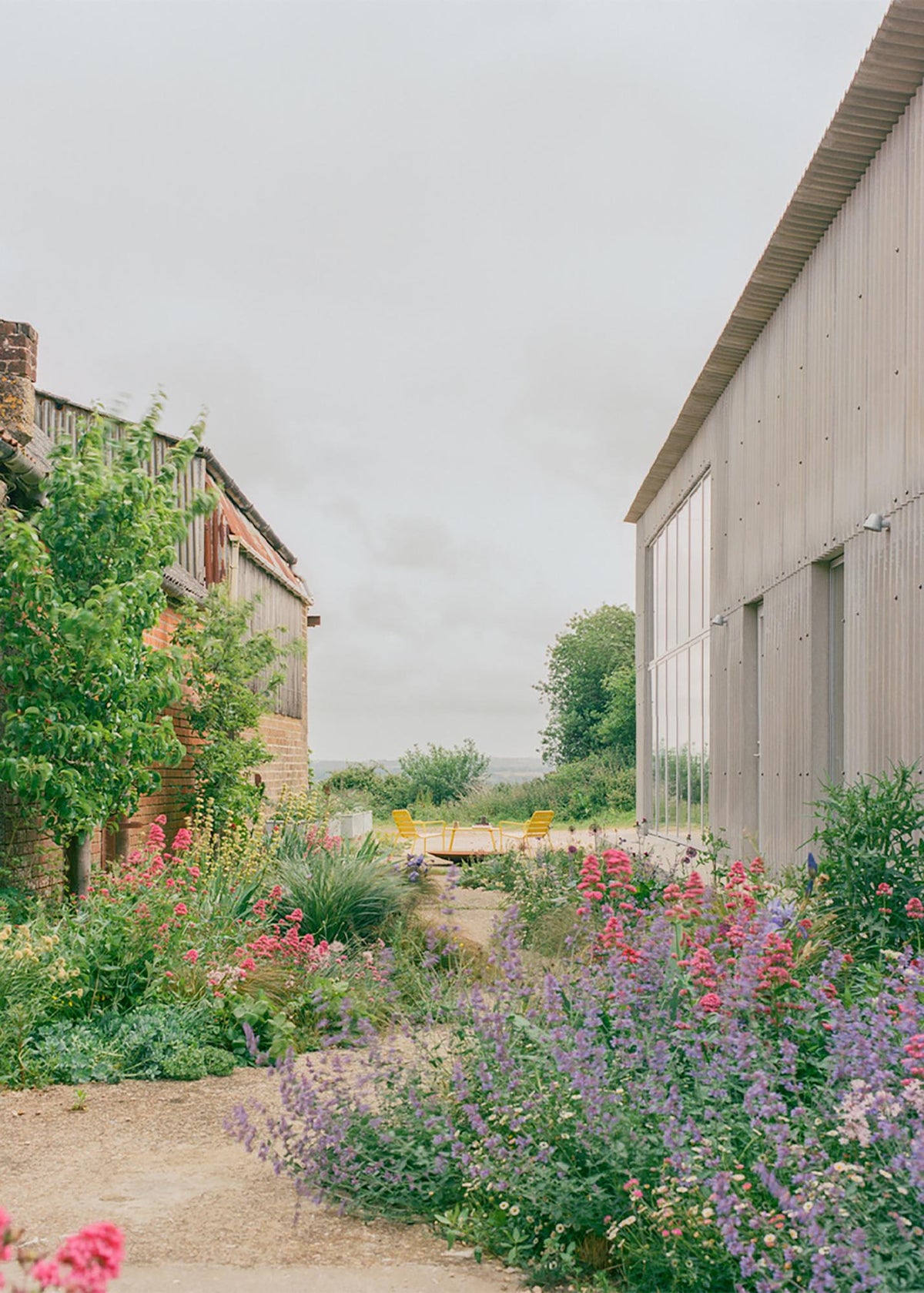 Planting and a narrow path connect South Barn with its working-farm setting.