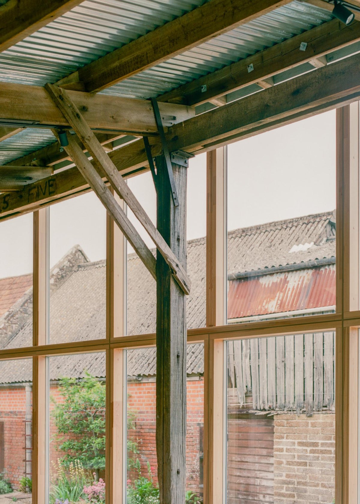 Retained timber bracing meets the new full-height glazing at South Barn.